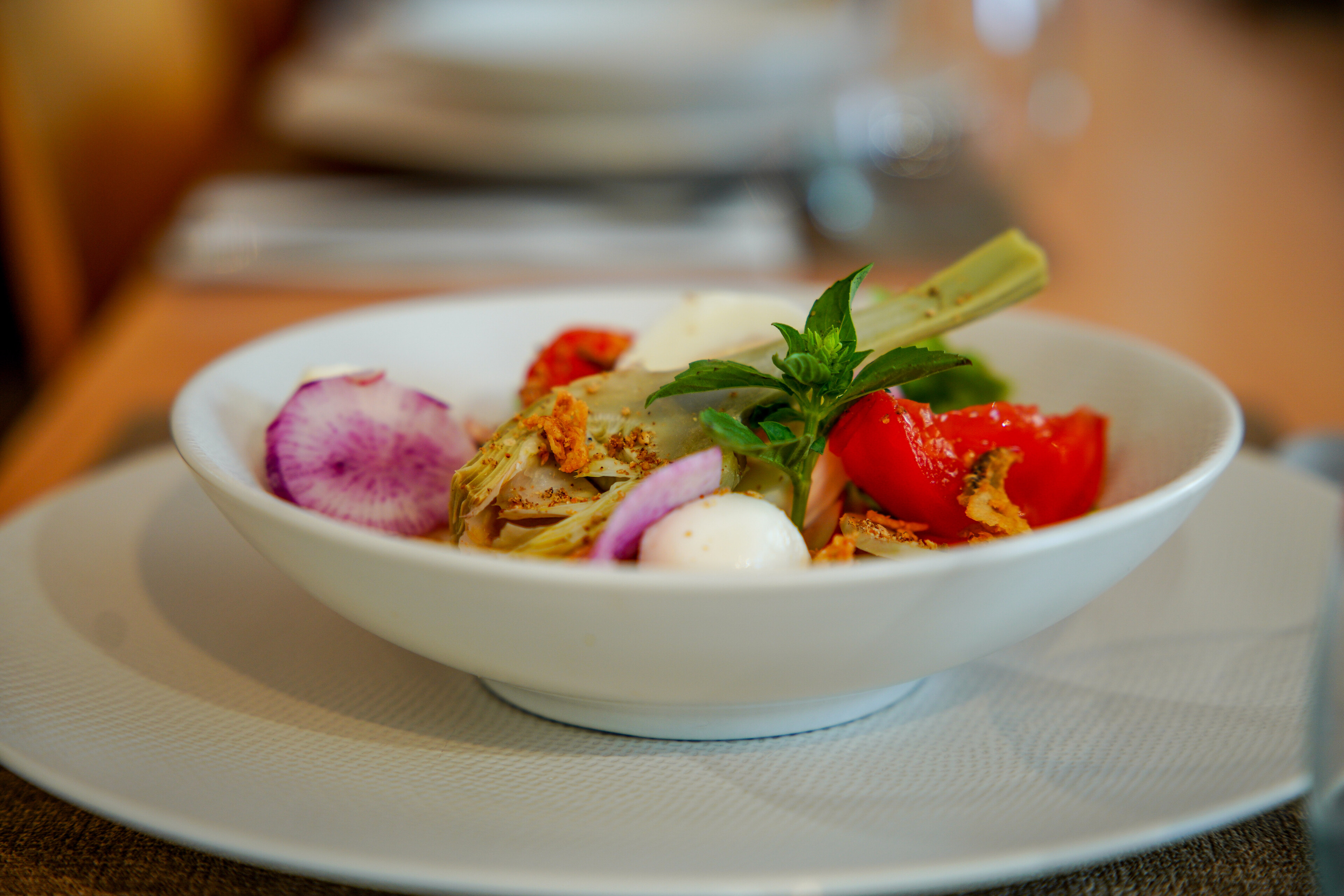 Image représentant une assiette creuse avec une salade composée pour diriger vers la catégorie restauration